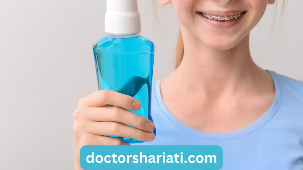 Smiling Teenage Girl with Dental Braces Holding Bottle of Mouthwash on Grey Background